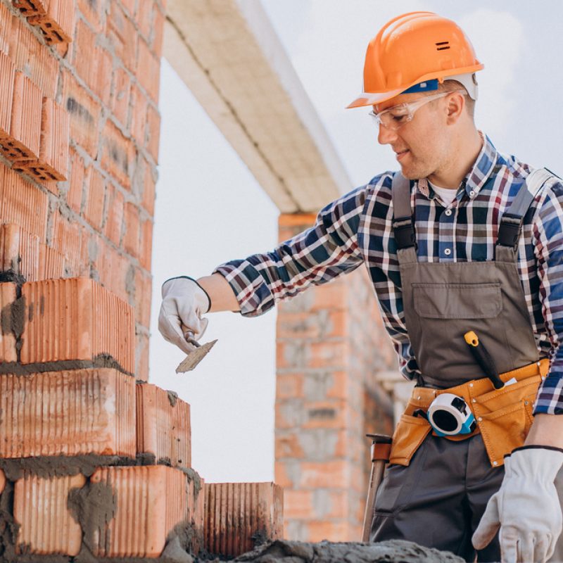 Young craftsman building a house